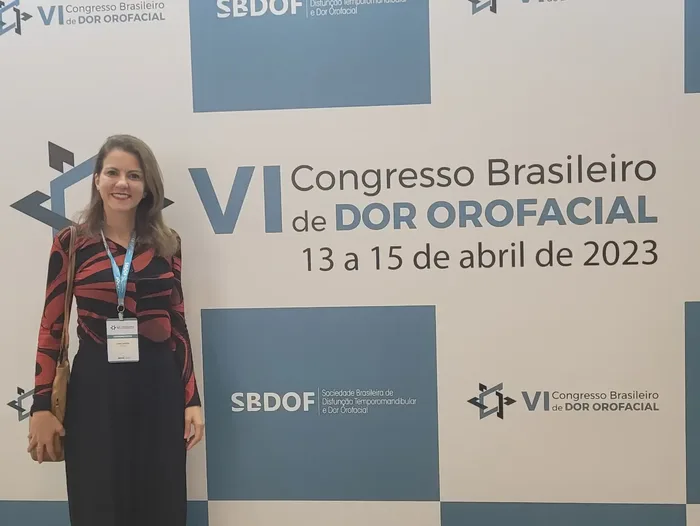 Dra. Júnia Santos diante do painel do VI Congresso Brasileiro de Dor Orofacial